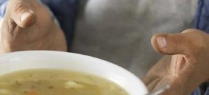 Hands of Homeless Man Receiving Bowl of Soup